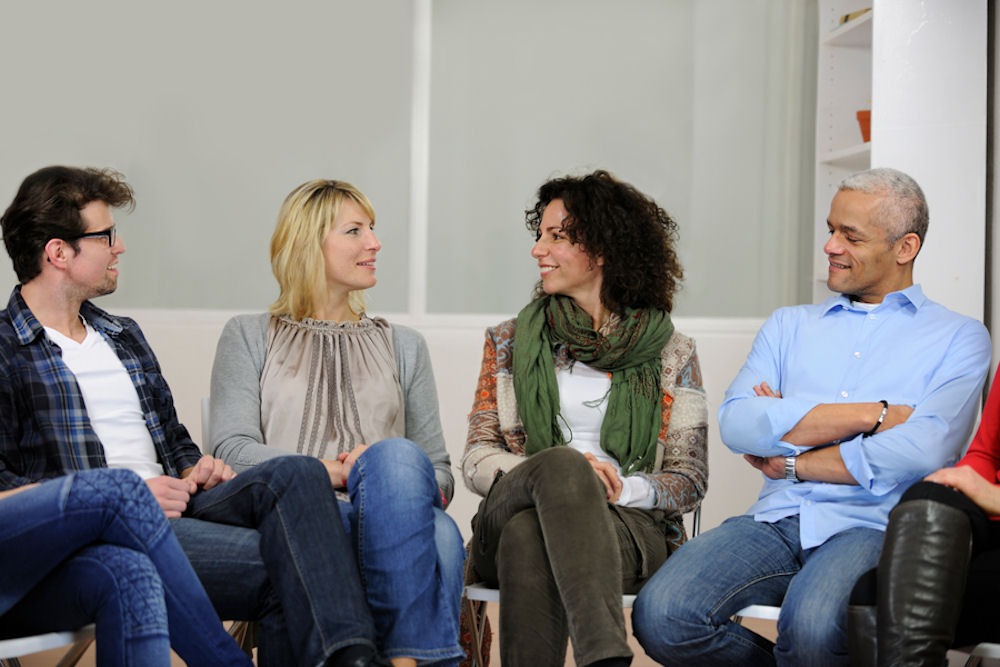 Mixed gender addiction support group discussing long-term recovery