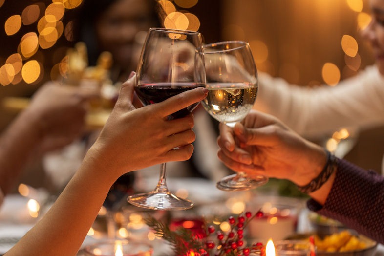 Picture of hands clinking glasses of red and white wine