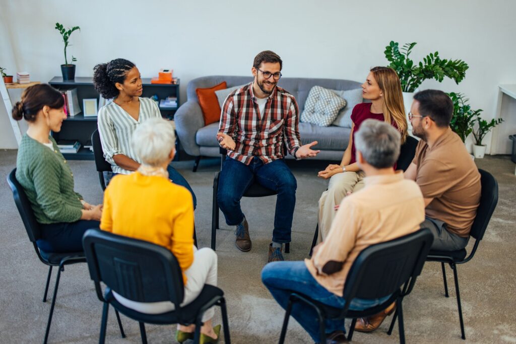 Mixed age and gender group discussing risk factors for substance abuse