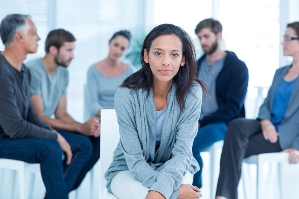 Woman facing outward from a mixed gender addiction support group at outpatient rehab in Texas