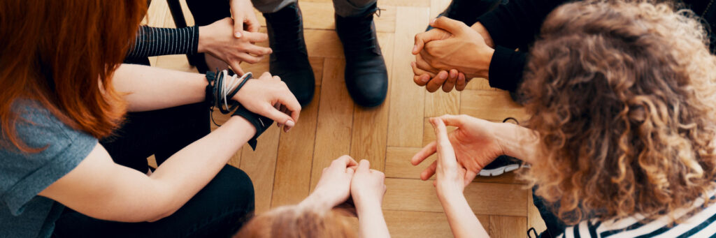 Overhead shot of a bipolar support group discussing things in a huddle style formation