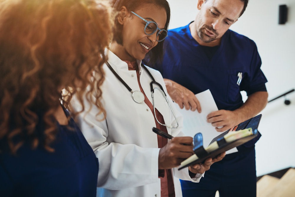 Doctor discussing chart showing patient's memory loss with two nurses