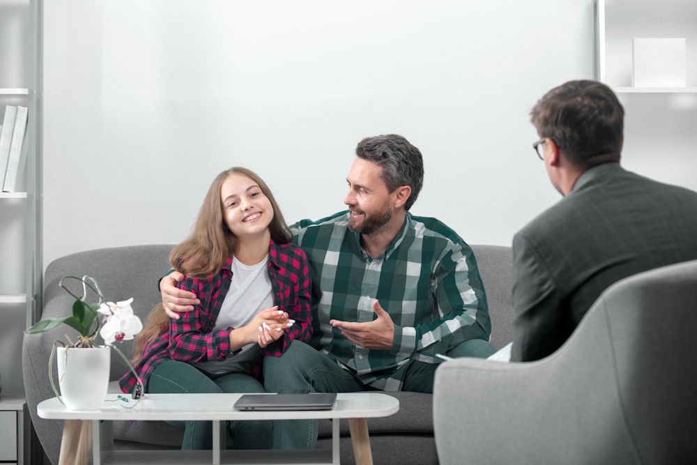 Man side hugs daughter during family therapy for inhalant addiction